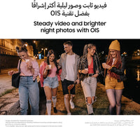 Group outdoors viewing smartphones at night; screens lit