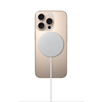 MagSafe charger on beige phone back, white puck and charging cable